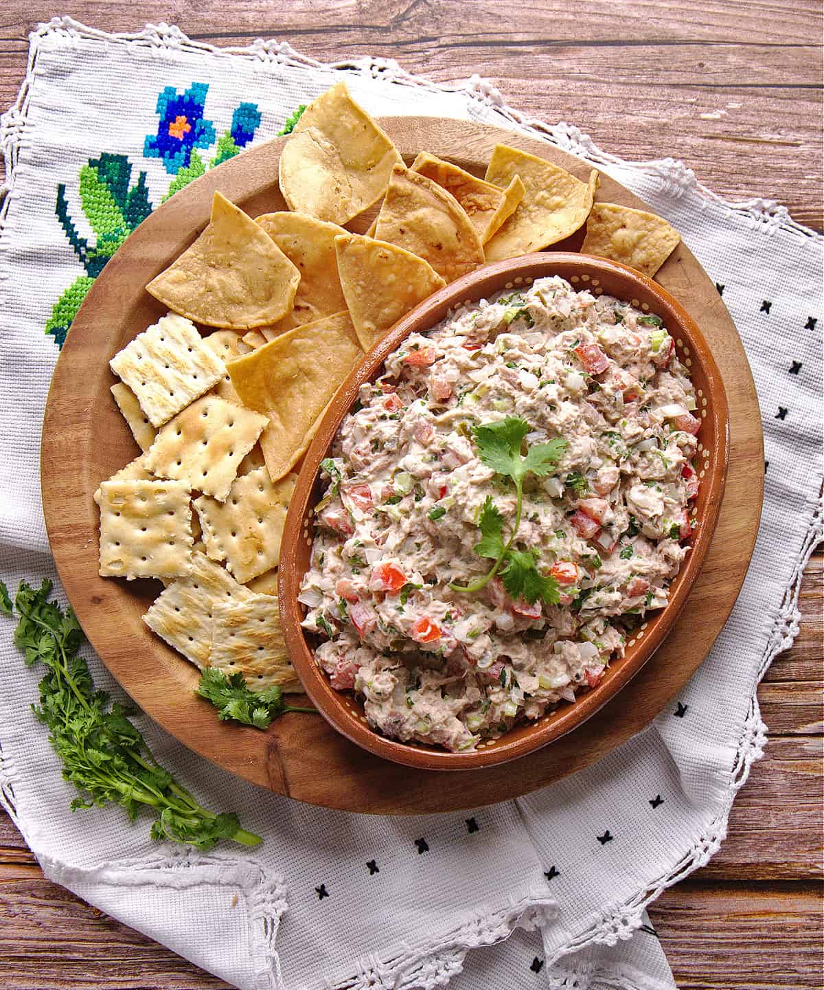 Ensalada de Atún served in a clay bowl and surrounded by chips and saltine crackers.