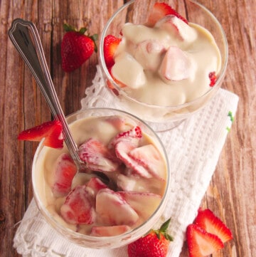 Two cups of Fresas con Crema served in a glass cup.