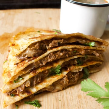 Slices of birria quesadillas stacked on top of each other.