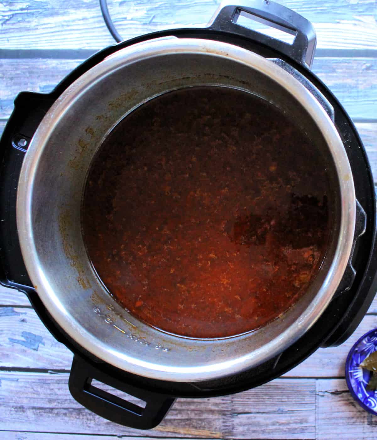 A picture of the birria consomme inside an instant pot.
