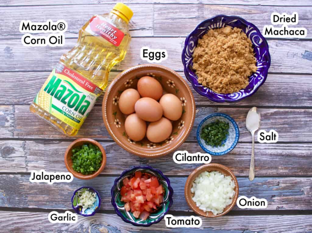 The ingredients needed to make beef machaca with eggs laid out on a table and labeled.