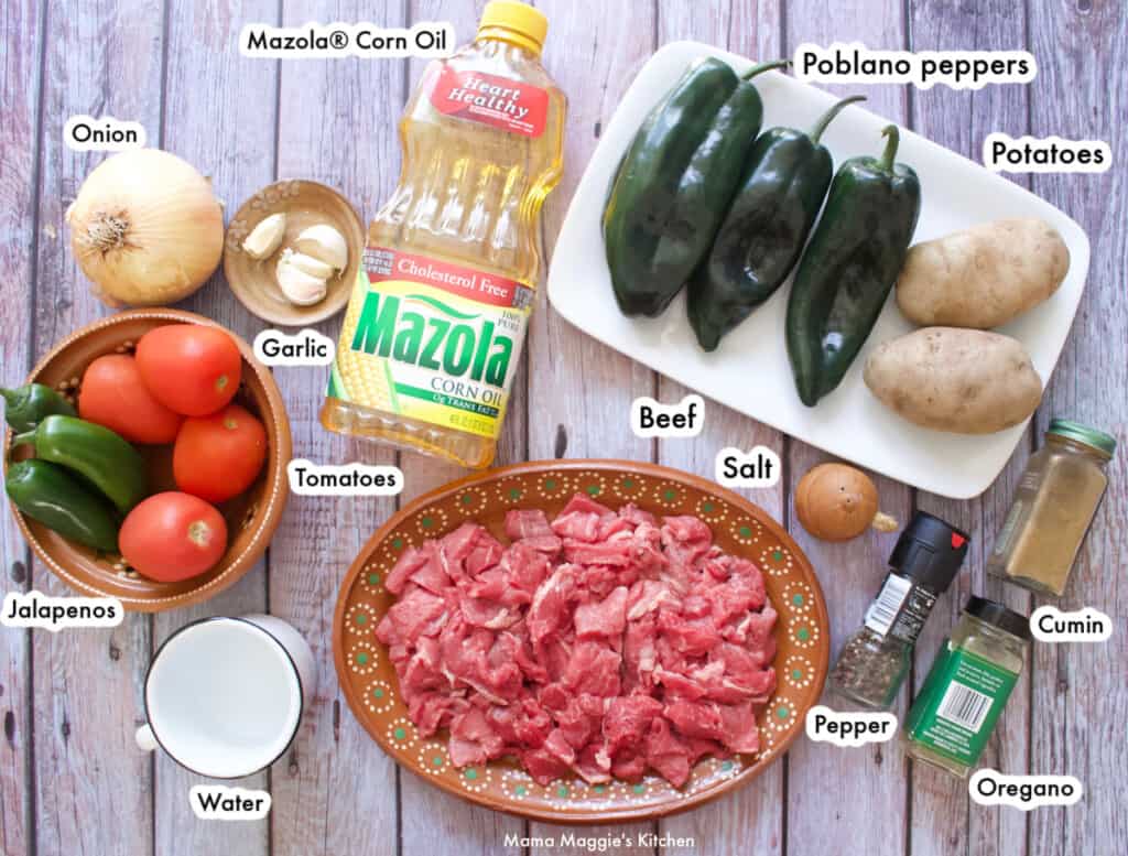 A picture of the ingredients needed to make Bistec Ranchero labeled and on a wooden table.