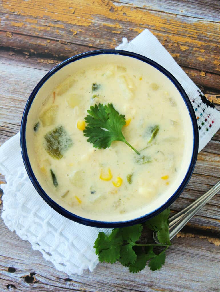 Caldo de Queso served in a bowl and topped with a cilantro leaf.