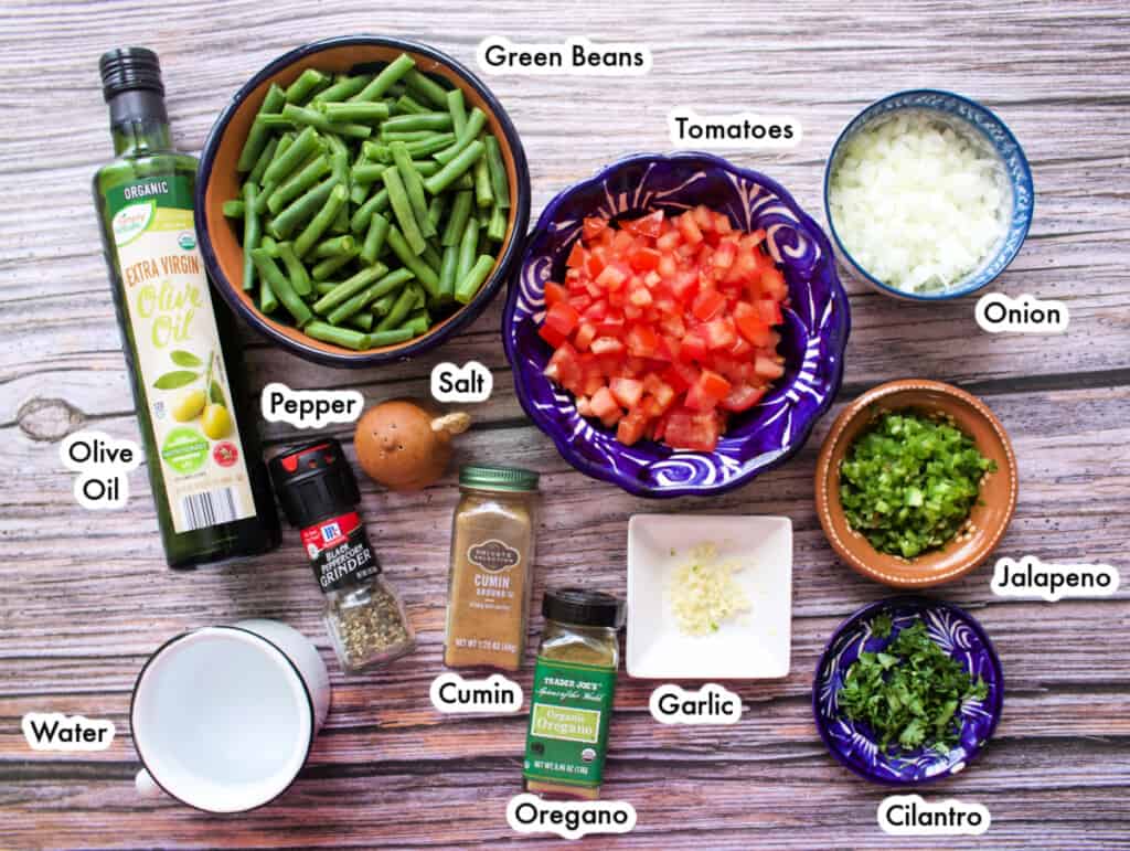 The ingredients needed to make Ejotes a la Mexicana spread out and labeled.