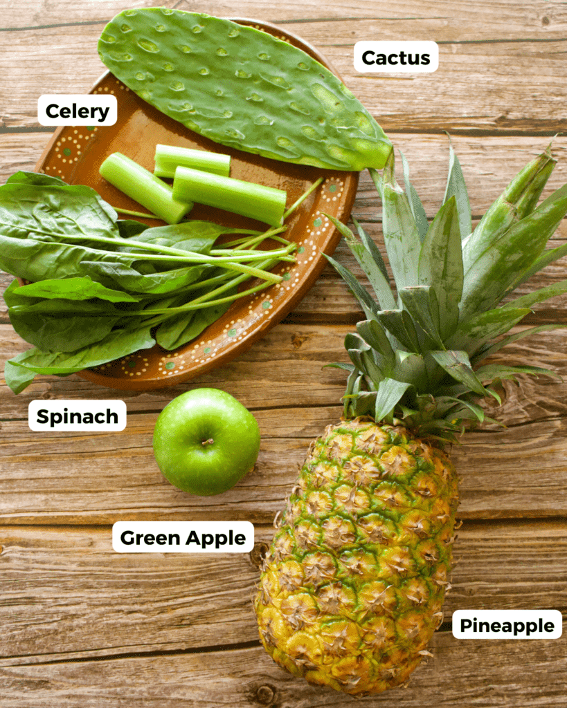 The ingredients needed to make Jugo Verde labeled and sitting on a wooden surface.