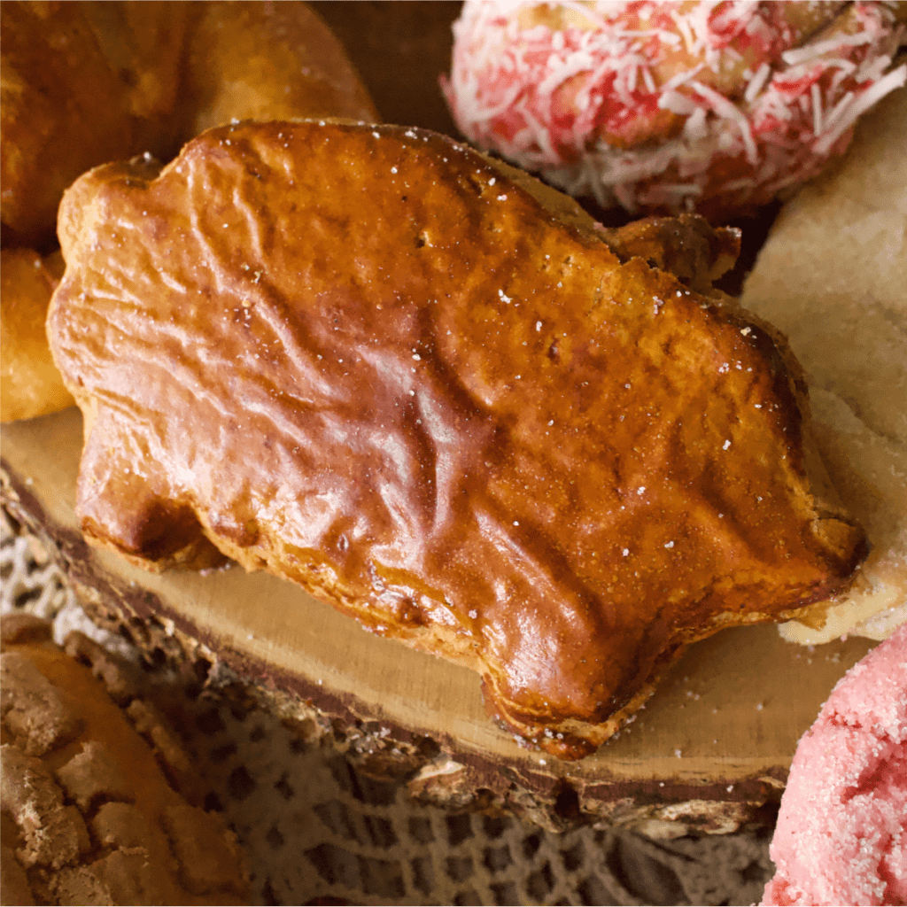 A marranito pan dulce, or Mexican gingerbread piggy, sitting on a wooden surface.