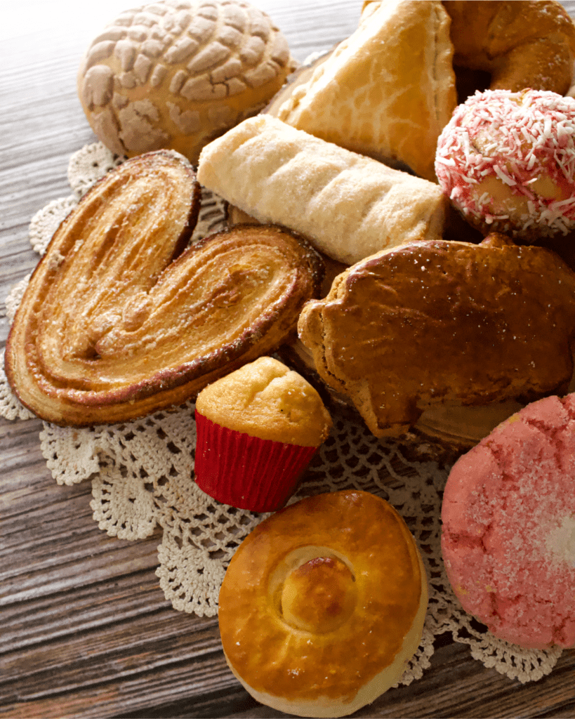 Mexican pan dulce (or sweet breads) sitting on a crocheted napkin.
