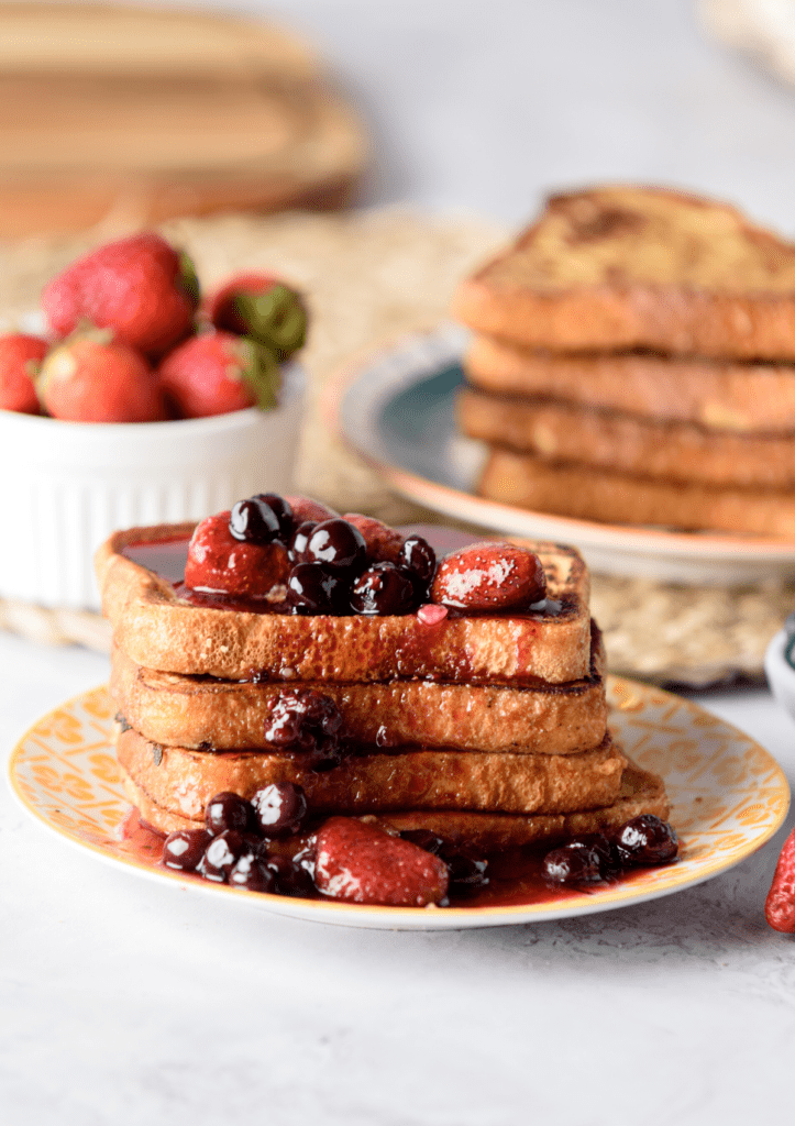 A stack of pan frances covered in berry syrup.