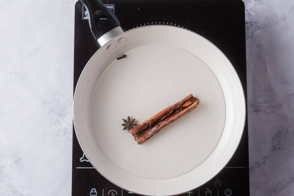Cinnamon stick, star anise and whole clove in a stockpot with water to make the cinnamon tea.