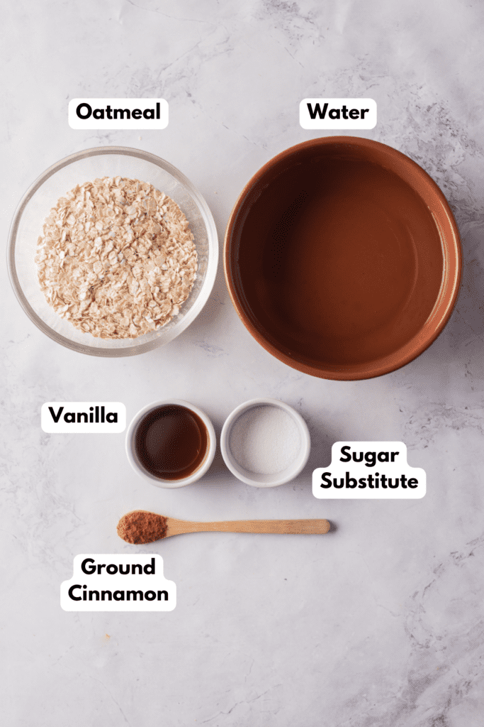 The ingredients needed to make oat water labeled and sitting on a white marble surface.