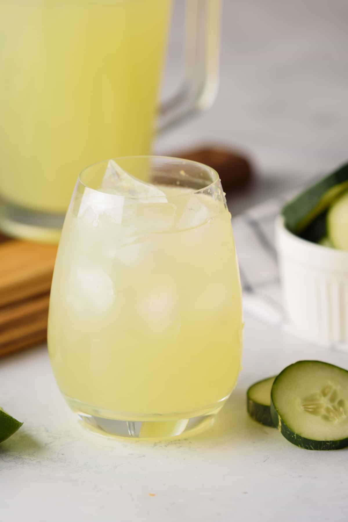 Agua de Pepino served in a glass next to cucumber slices.