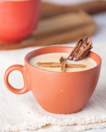 Atole de arroz served in a mug with a piece of whole cinnamon on top.
