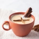 Atole de arroz served in a mug with a piece of whole cinnamon on top.