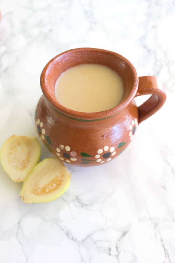 Atole de guayaba served in a decorative Mexican clay mug.