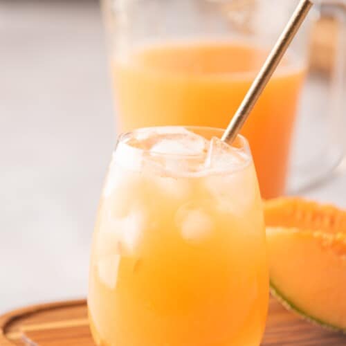 Cantaloupe Agua Fresca served with ice in a glass.