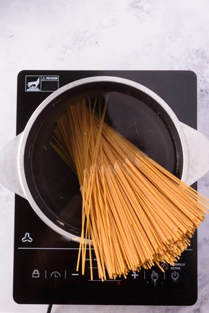 Cooking spaghetti pasta in a large pot with water.