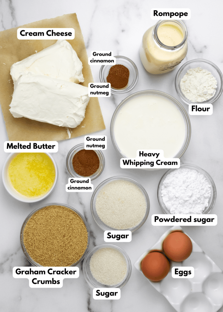 The ingredients needed to make the Rompope Cheesecake Bites labeled and sitting on a white marble surface.