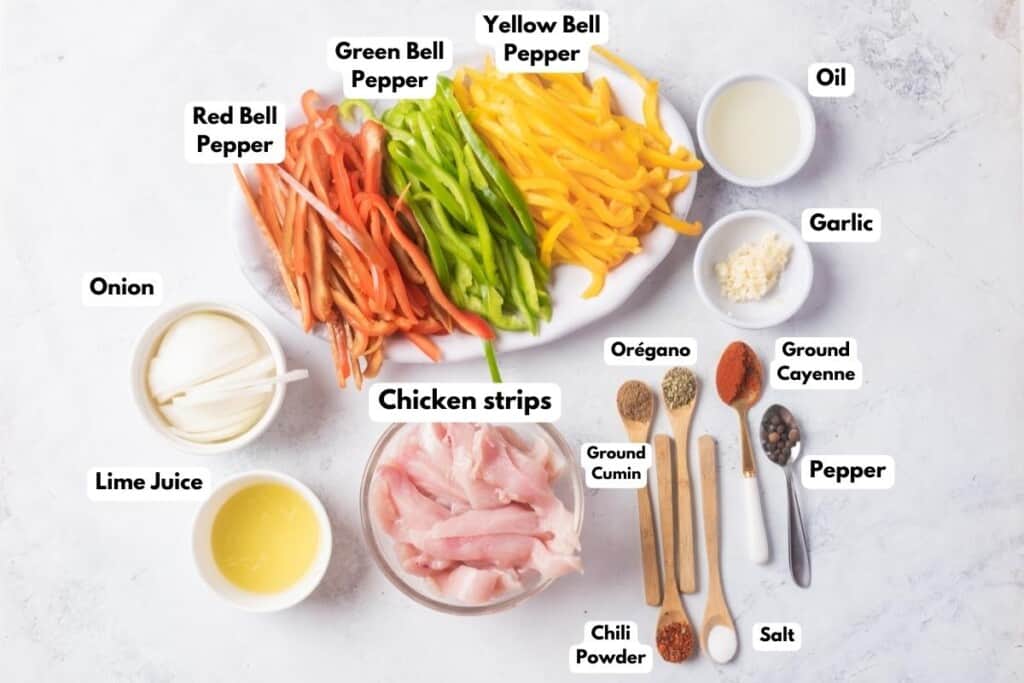 The ingredients needed to make Chicken Fajitas labeled and sitting on a marble surface.