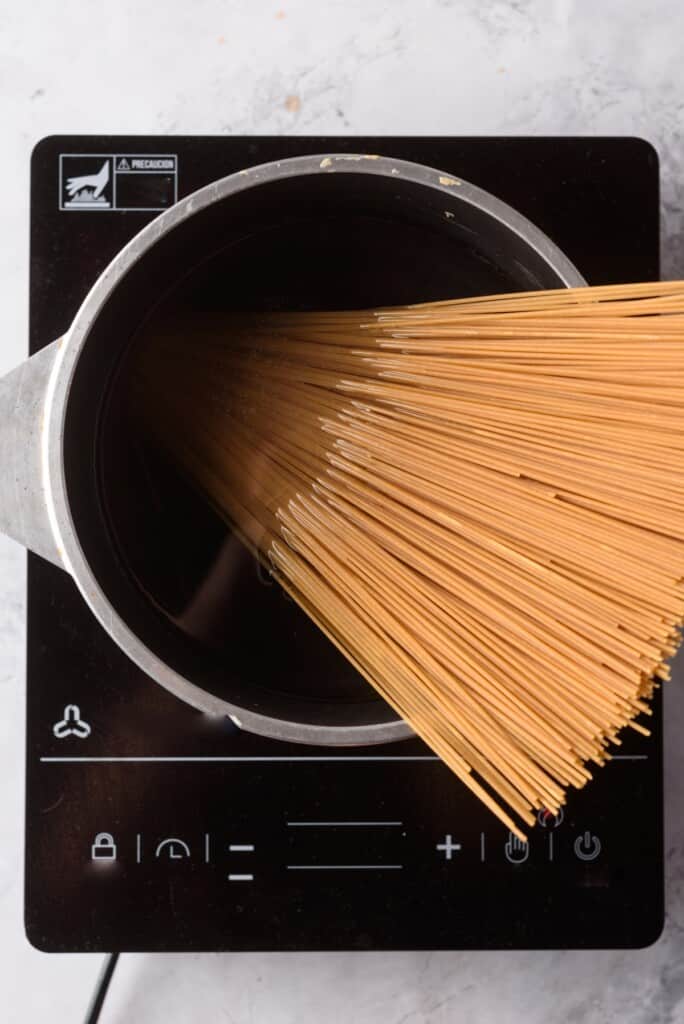 Cooking dry spaghetti in a stockpot with water.