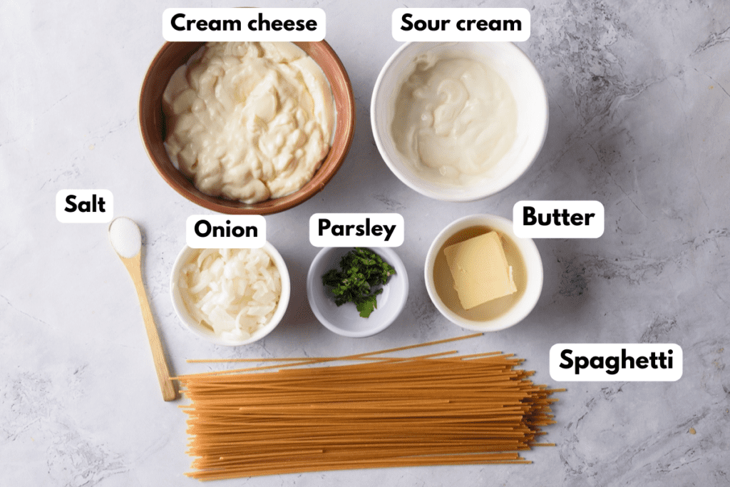 The ingredients needed to make Mexican white spaghetti labeled and sitting on a marble surface.