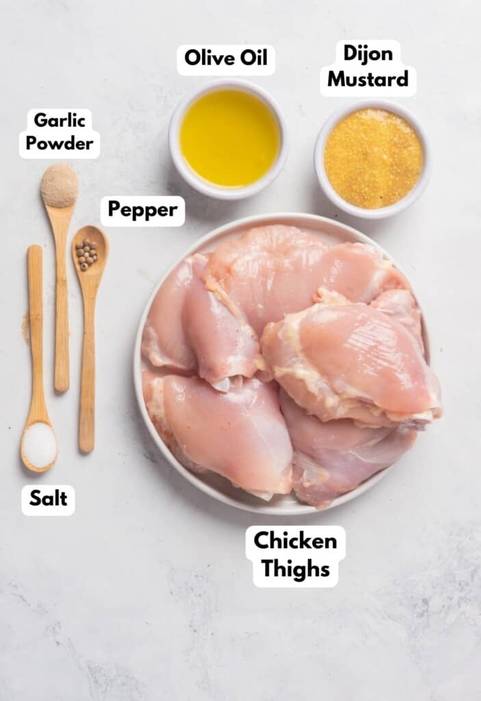 The ingredients needed to make Pollo a la Mostaza labeled and sitting on a white marble surface.