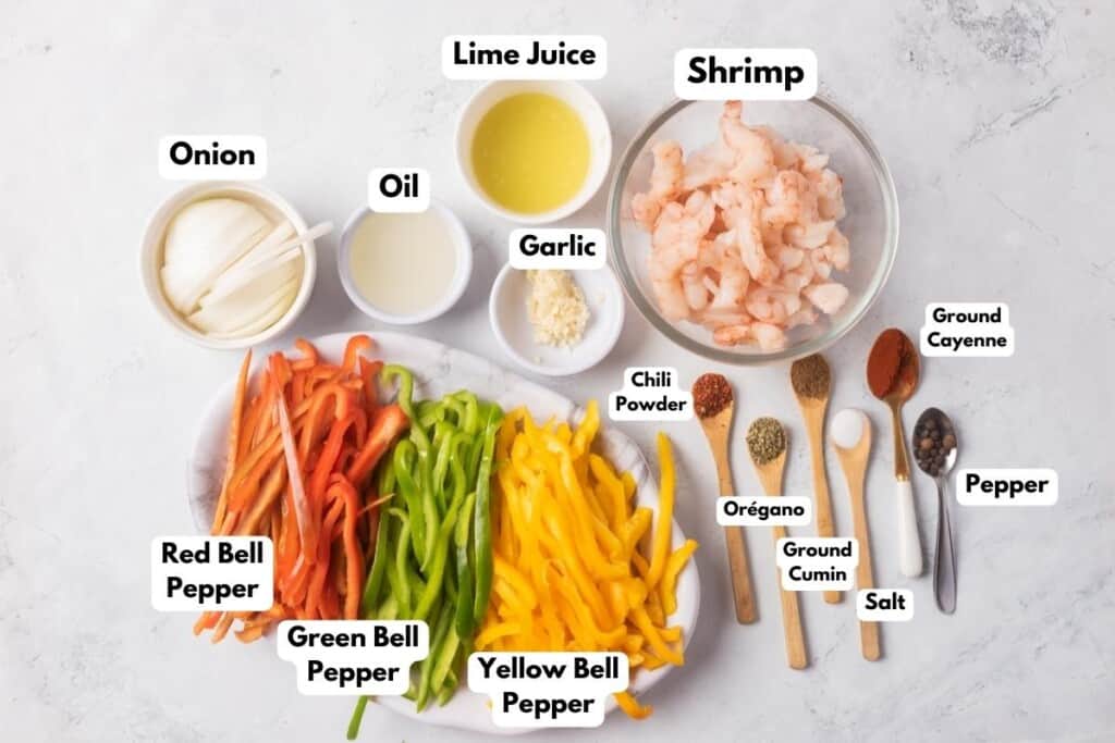 The ingredients needed to make Shrimp Fajitas labeled and sitting on a marble surface.