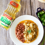 Turkey picadillo served on a white plate next to a bottle of Mazola Corn Oil.