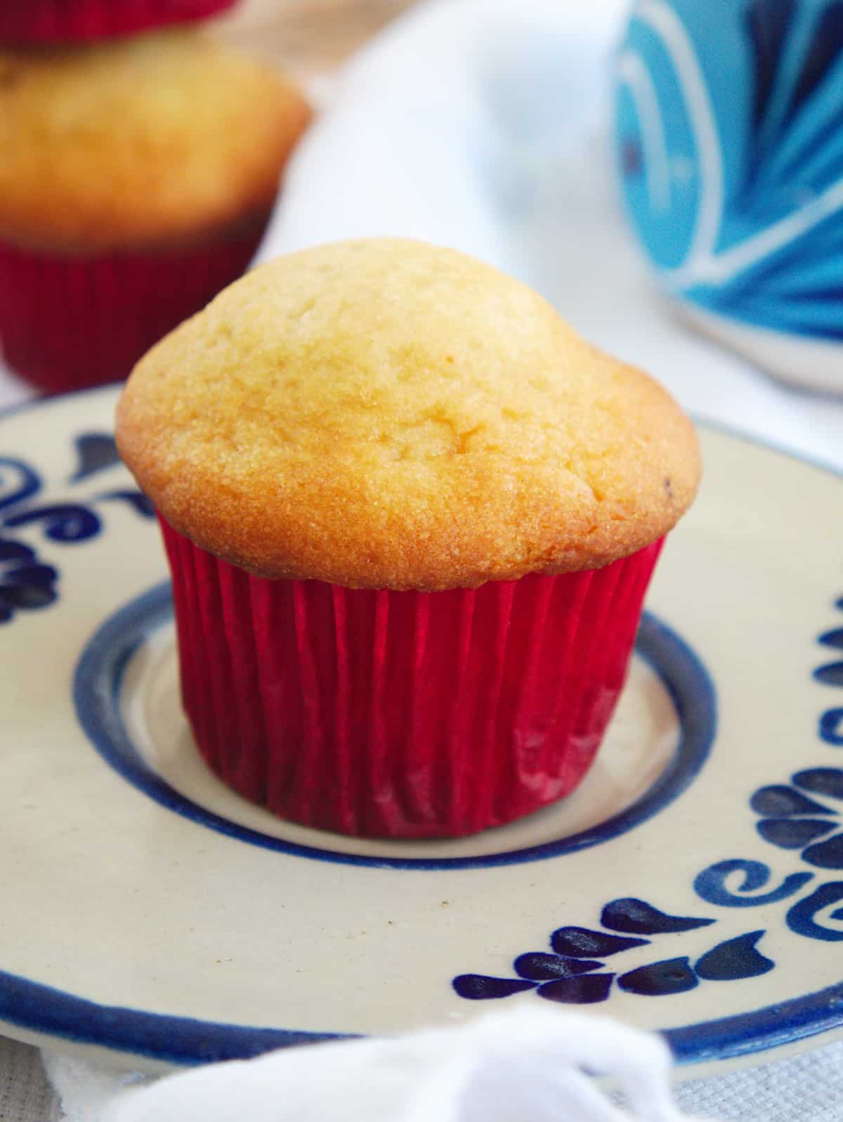 A single Mexican muffin with a red cupcake liner sitting on a decorative blue plate.