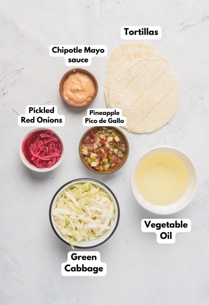 The ingredients need to assemble the tacos labeled and sitting on a marble surface.