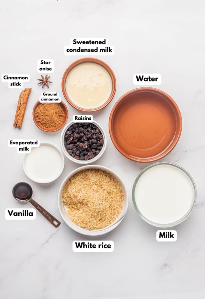 The ingredients needed to make Mexican Arroz con Leche labeled and sitting on a marble surface.