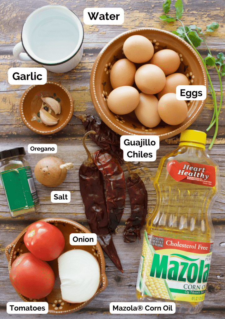 The ingredients needed to make Huevo en Salsa labeled and sitting on a wooden surface.