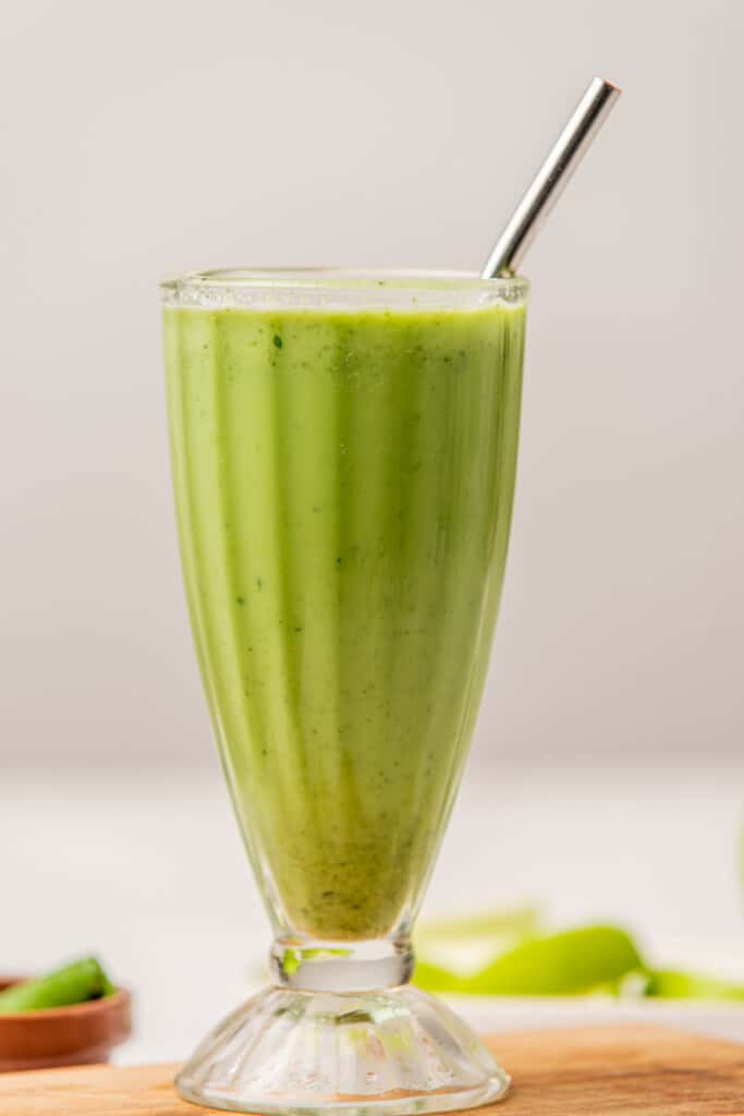 Green Ginger Smoothie served in a glass with a metal straw.