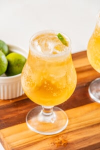 A chelada served in a glass with a lime wedge.