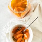 Mexican Pickled Carrots served in a white bowl next to a glass jar.
