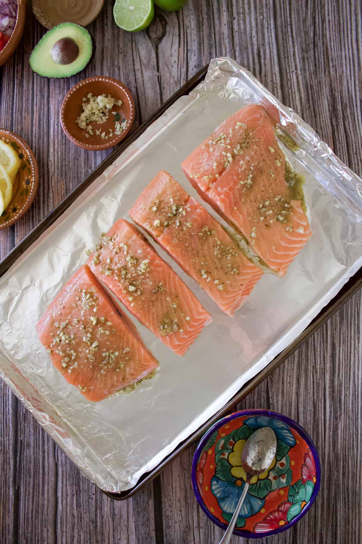 Raw salmon filets on a baking sheet.