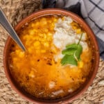 Sopa de Elote served in a bowl and sitting on a placemat.