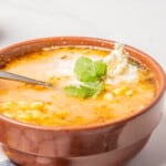 Sopa de Elote served in a bowl with cheese and cilantro for garnish.