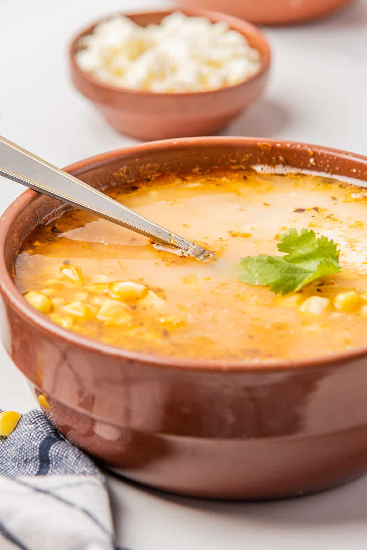 Sopa de Elote topped with cheese and cilantro.
