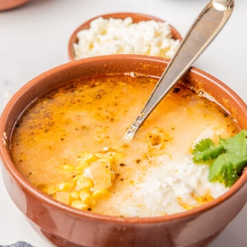 Sopa de Elote topped with cheese, cream, and fresh cilantro.