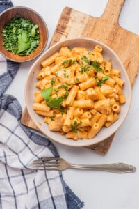 A bowl of spicy chicken chipotle pasta topped with chopped parsley.