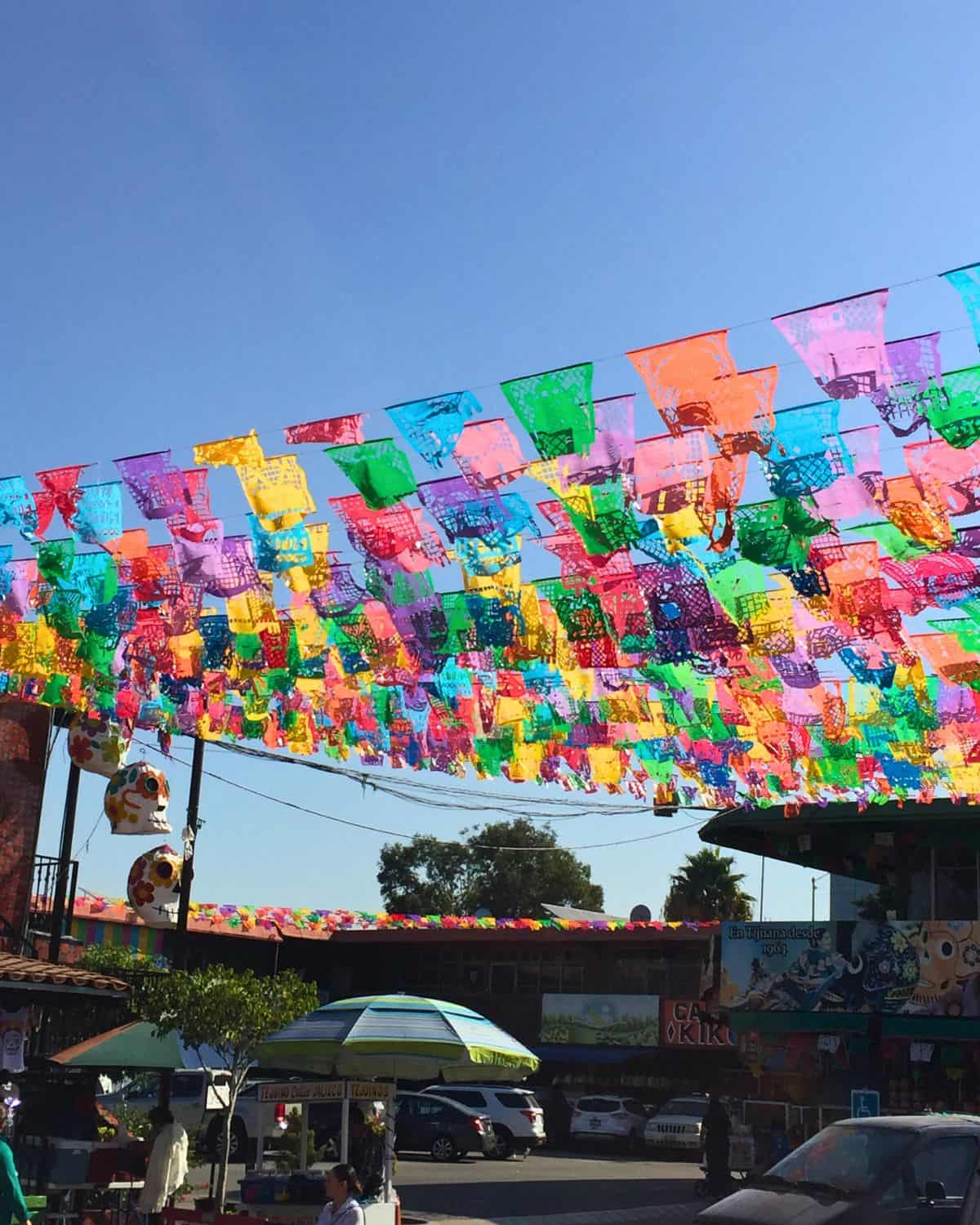 Decorative papel picado flying from the roof at a Mexican market.