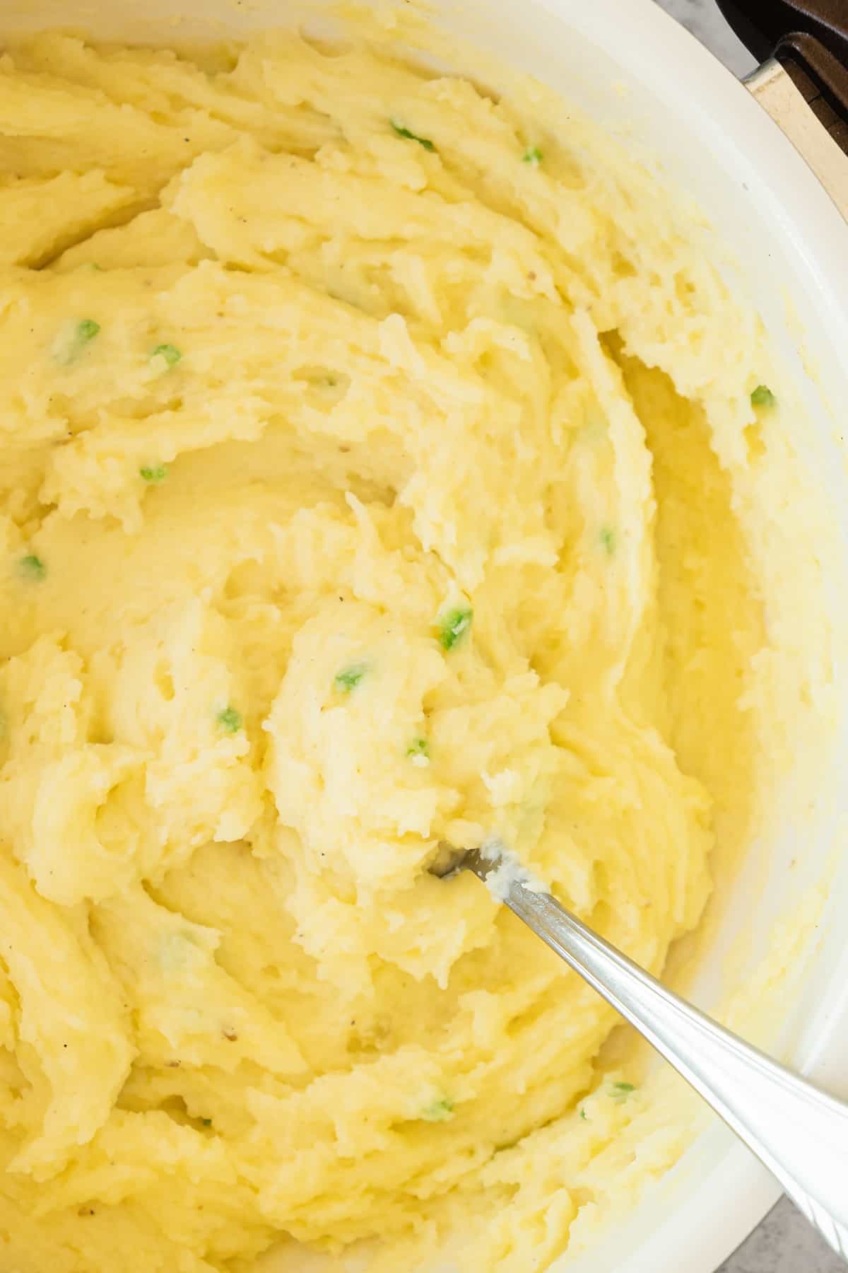 Mixing creamy mashed potatoes in a bowl.
