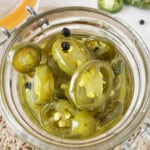 A glass jar with sweet pickled jalapenos.