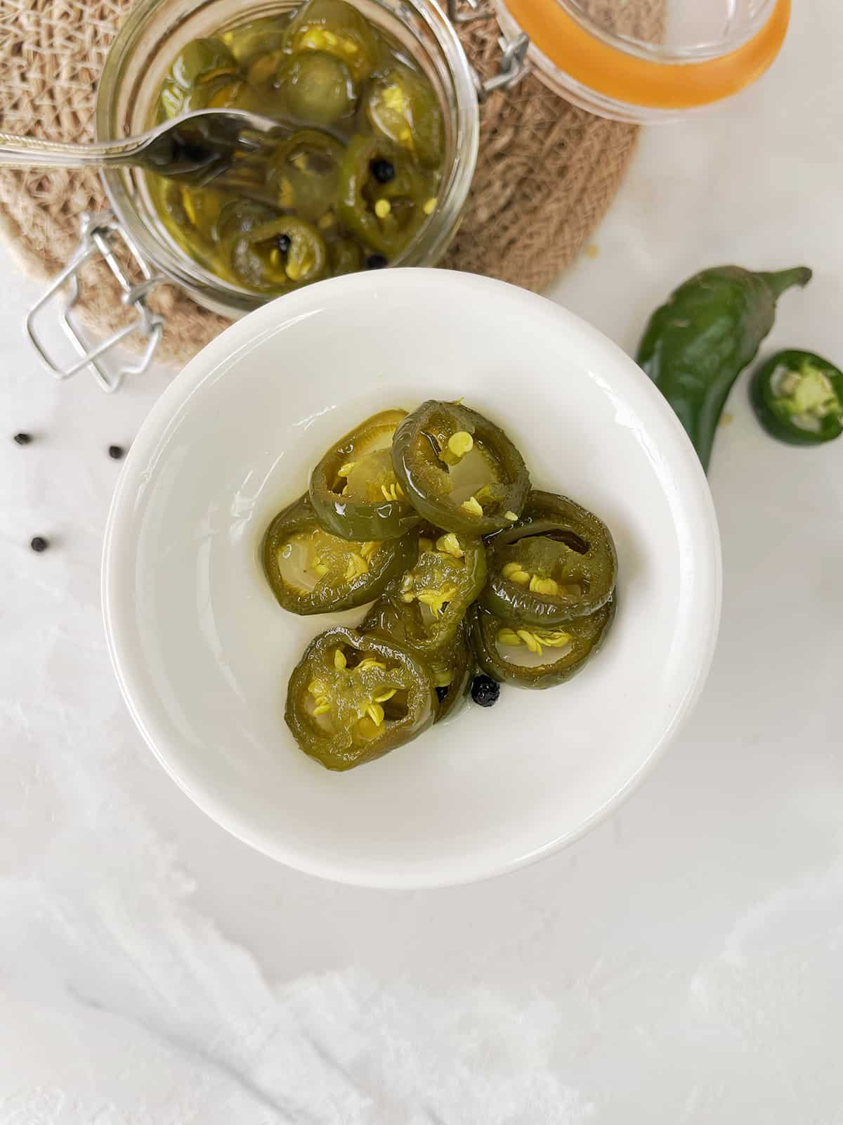 A white bowl with sweet pickled jalapenos.