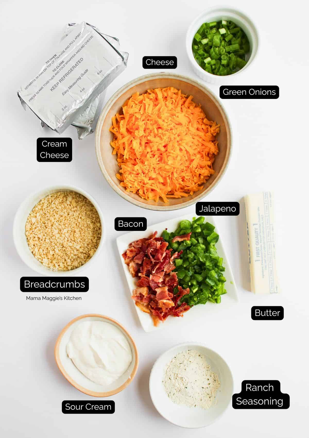 Top-down view of ingredients in separate bowls and plates: shredded cheese, chopped green onions, cream cheese, breadcrumbs, bacon bits, diced jalapeño, butter, sour cream, and ranch seasoning. Labels name each item.