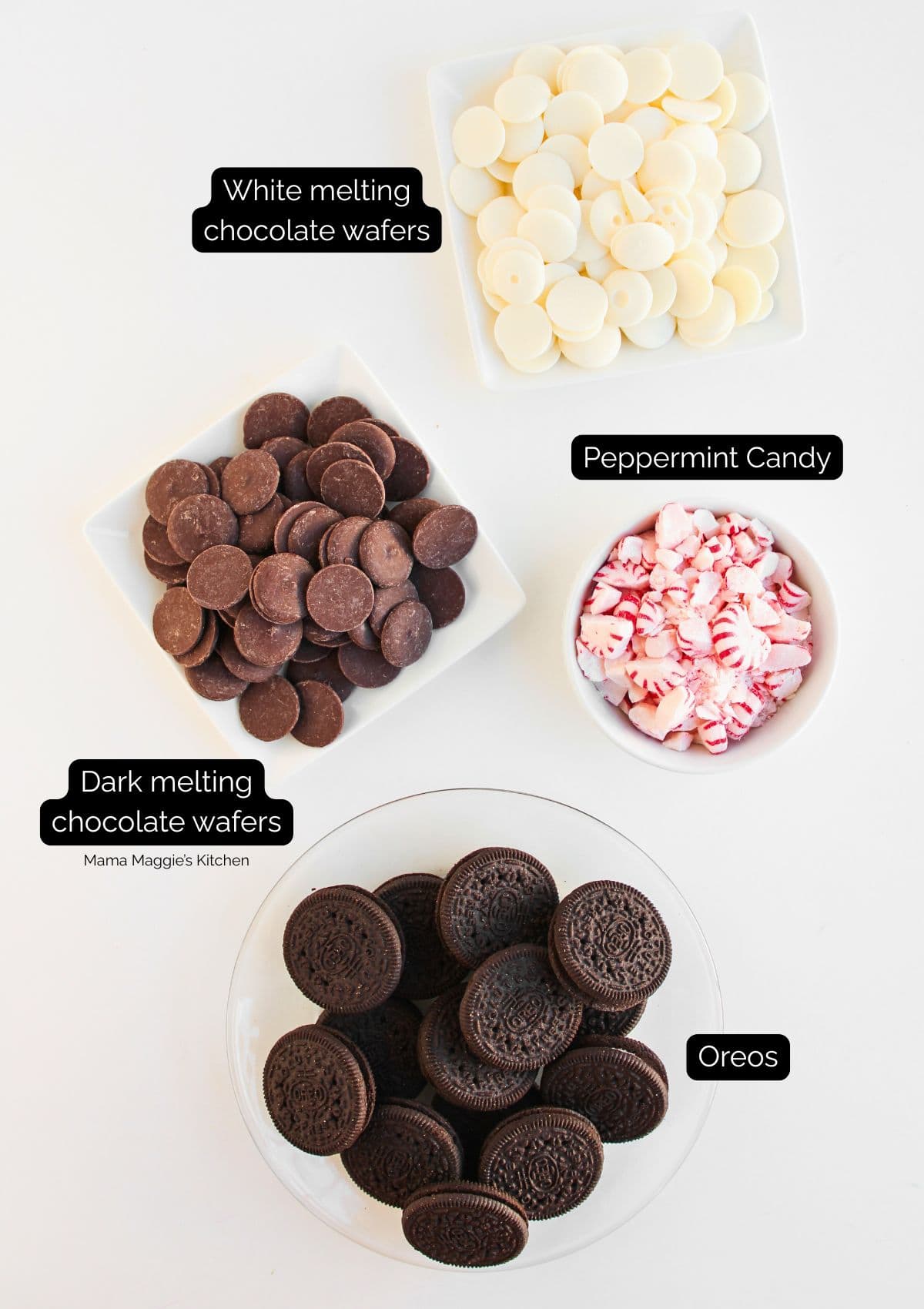 Four bowls on a white surface containing white melting chocolate wafers, dark melting chocolate wafers, crushed peppermint candy, and Oreo cookies, each labeled with black text boxes.