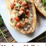 Two halves of bread rolls topped with refried beans, melted cheese, and fresh pico de gallo sit on a white plate. Text at the bottom reads “Mexican Molletes Open-Faced Sandwiches.”.